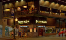 The exterior of Smith & Son Corner Kitchen in Gatlinburg at night with people walking around on the sidewalk.